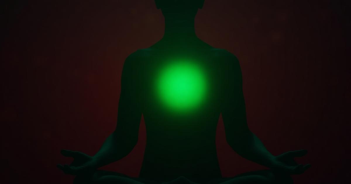 Green light glowing at the chest of a calm seated silhouette against a dark maroon background
