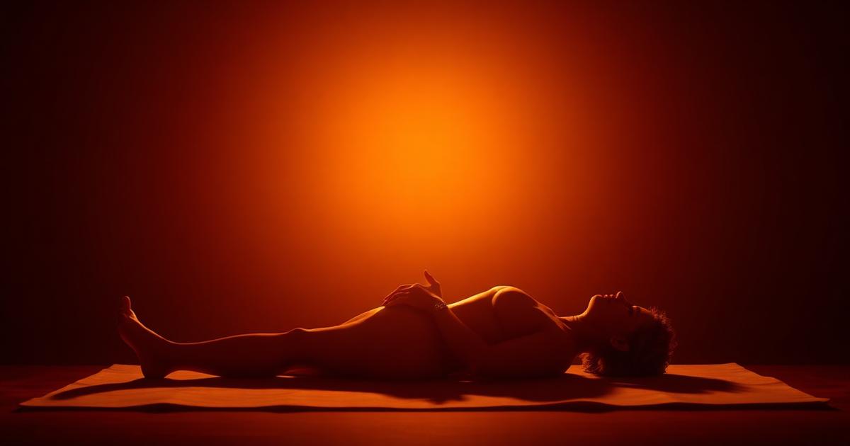 A person lying relaxed under warm saffron light during a no-touch pranic healing session