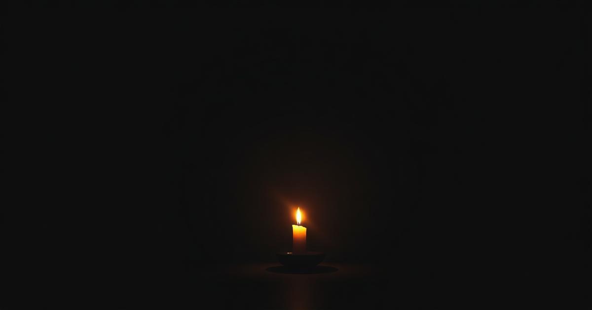 A single candle flame burning steadily in a dark room, used as a focus point for trataka